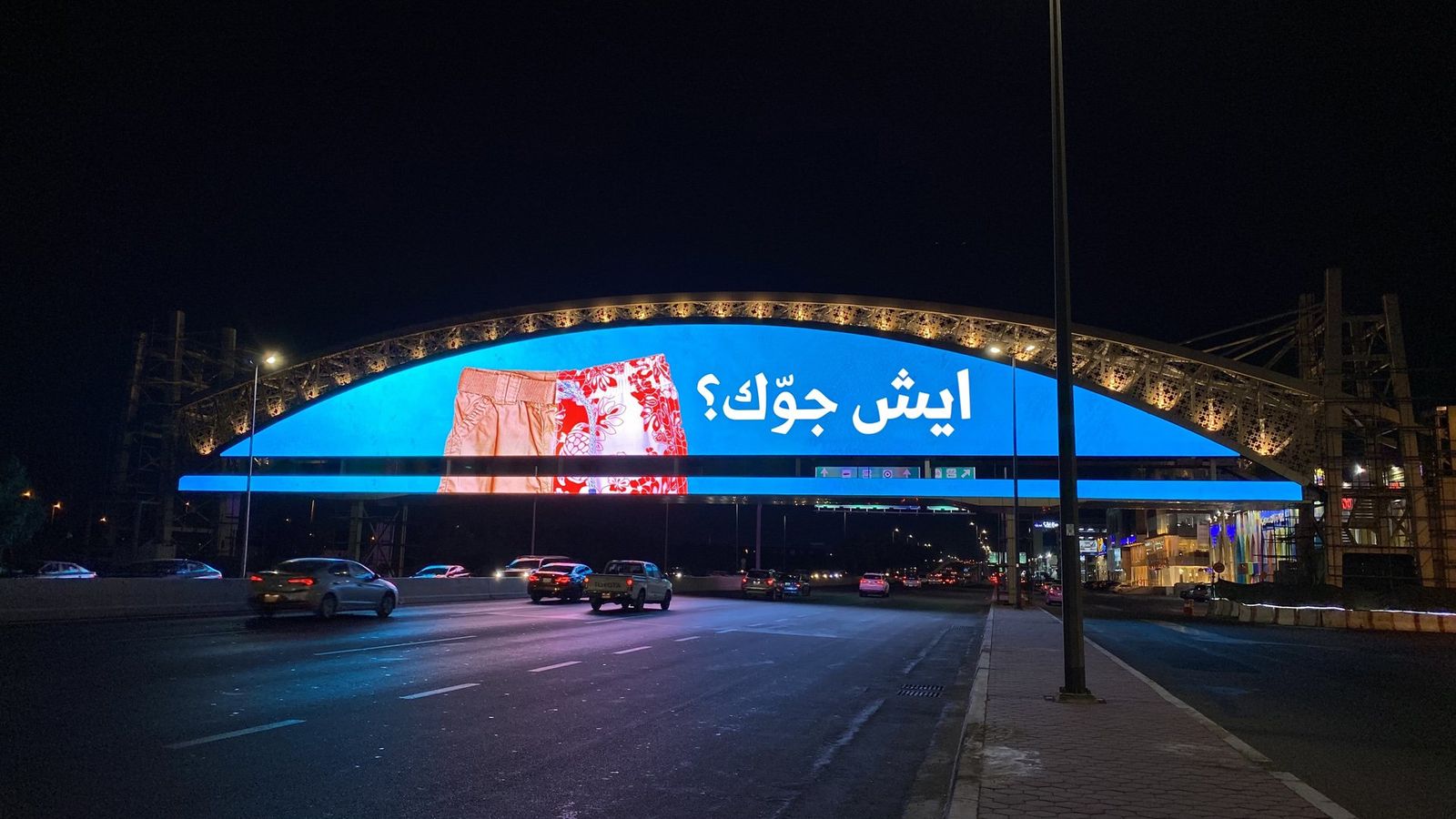 Ministry of Tourism bridges campaign on a curved LED bridge screen in Jeddah at night