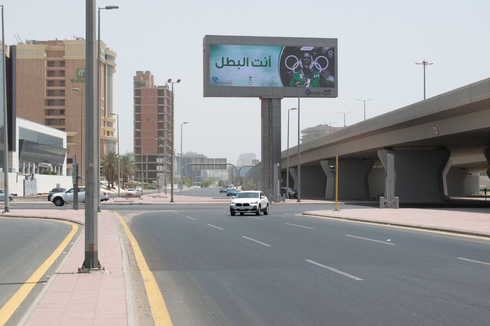 Bridge banner reading You are the champion over a Jeddah road